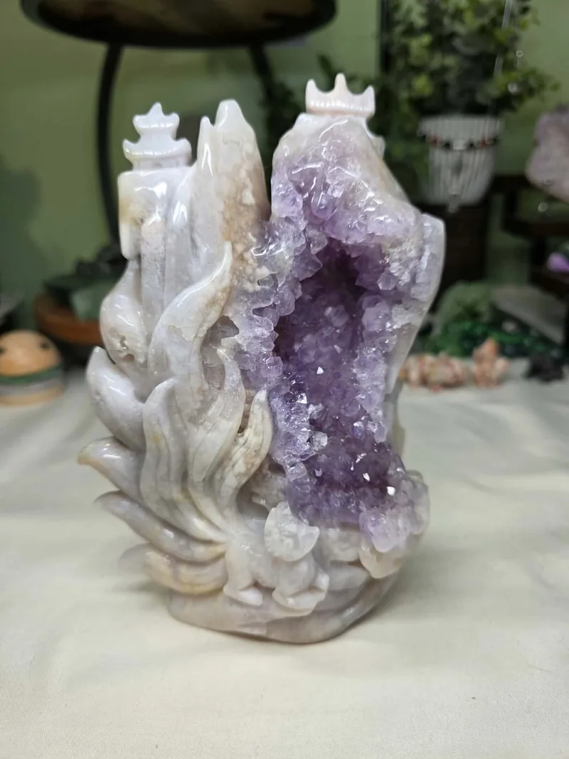 A pale stone landscape carving with small tiered towers around a purple crystal-lined center.