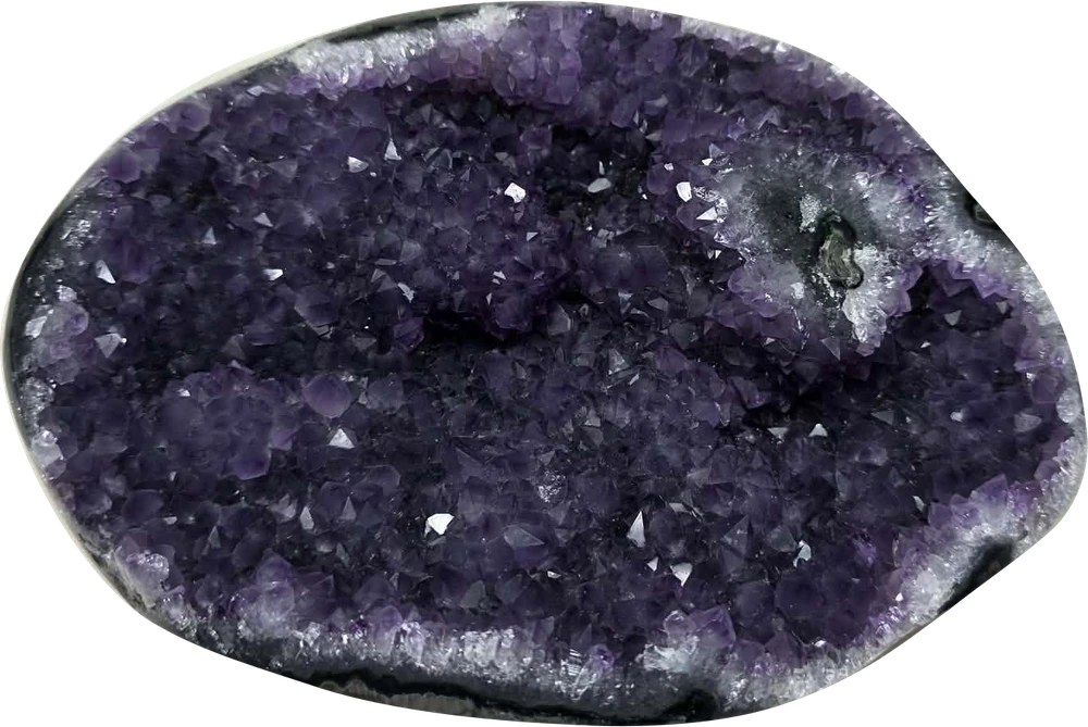 Ann’s oval amethyst geode with a deep purple, densely faceted crystal center.